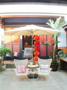 two chairs and a table with an umbrella on a patio at 依山行館 浪漫恬靜落角處 盡享古厝慢旅時光 in Jincheng