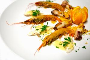 a plate of food with seafood on a white plate at Hotel Villa Margherita in Quercianella