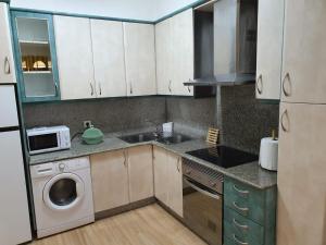 a kitchen with a sink and a washing machine at Sol in Cangas de Morrazo