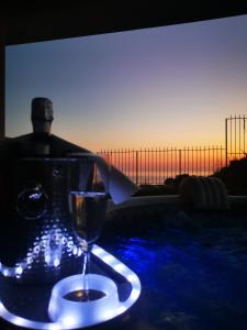 a glass of wine sitting on a table with a view of the ocean at La Dolce Dimora in Praia a Mare
