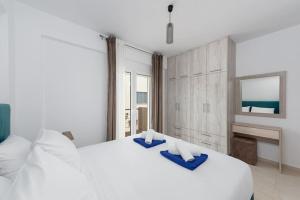 a bedroom with a large white bed with blue towels on it at G Berdufi 2 bd with parking in Eloúnda in Elounda