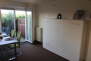 a room with a table and a white cabinet at Ferienwohnung Martje vom Deich, Kalifornien, erste Strandreihe in Schönberg