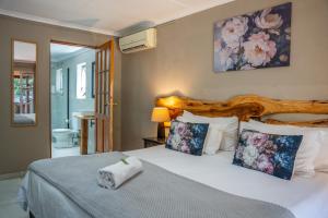 a bedroom with a bed with a wooden headboard and pillows at Tidewaters River Lodge in Gonubie