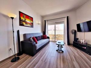 a living room with a couch and a television at Sea View 2-beds 'Estrela' Apartment - Praia da Luz in Luz
