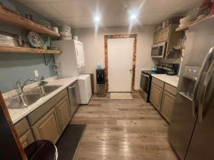 a kitchen with a sink and a refrigerator at Legacy Barn on Sugar Creek in Bentonville