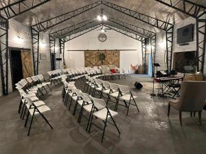 a room with a bunch of chairs and a stage at Legacy Barn on Sugar Creek in Bentonville