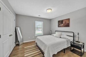ein weißes Schlafzimmer mit einem Bett und einem Fenster in der Unterkunft Stonecrest 717, 2bd Apt I Free Parking I Pool in New Albany