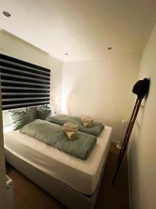 a bedroom with a large bed with green pillows at Modern Tiny House Sari in Zeeland near the sea in Heinkensand
