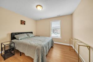 ein Schlafzimmer mit einem Bett und einem Fenster in der Unterkunft Stonecrest 701, 2bd Apt I Free Parking I Pool in New Albany + 23 Fotos