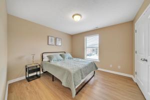 ein Schlafzimmer mit einem Bett und einem Fenster in der Unterkunft Stonecrest 701, 2bd Apt I Free Parking I Pool in New Albany
