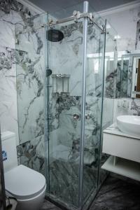 a bathroom with a shower with a toilet and a sink at Qadim Hotel in Samarkand +58 photos