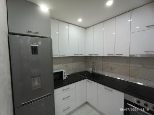 a kitchen with white cabinets and a stainless steel refrigerator at Apartman Lukić Bratunac in Bratunac