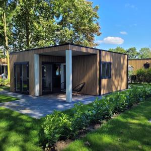 a small building with a chair in a yard at Modern Tiny House Sari in Zeeland near the sea in Heinkensand
