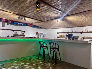two bar stools at a green counter in a restaurant at Paradiso Hostel El nido in El Nido