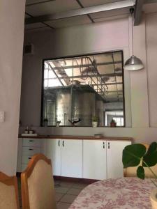 a kitchen with white cabinets and a large window at Winecellar Cave, on wine farm & where lions roar! in Stellenbosch