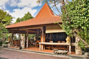 a gazebo with a table and a roof at Bali Telaga Hati Yoga Healing And Retreat Center Hostel in Sanur