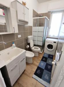 un piccolo bagno con un water e un lavandino di Renesmee Beach Apartment a Pietra Ligure