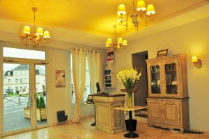 a room with a vase of flowers on a table at The Originals Boutique, Hôtel Les Poèmes de Chartres (Inter-Hotel) in Chartres