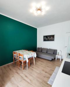 un soggiorno con tavolo, sedie e divano di Renesmee Beach Apartment a Pietra Ligure