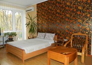 1 dormitorio con cama y pared de flores en Apartments Zatyshok, en Cherníhiv