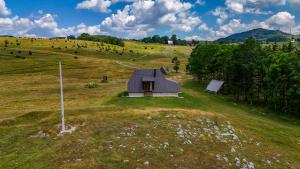 a small house in a field of grass at Zelenova koliba in Žabljak