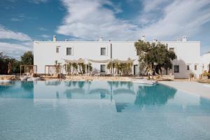 a large swimming pool in front of a white building at Masseria Torrepietra in Monopoli