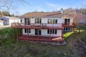 a large house with a large deck on a yard at Waterfront Retreat By Henn House Properties in Cheboygan