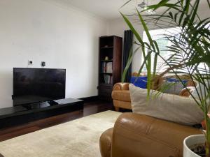 a living room with a couch and a flat screen tv at 2 bed Serviced Apartment in Henley in Henley on Thames
