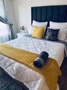 a bedroom with a large bed with a blue headboard at Golden Glory Manor in Roodepoort +25 photos