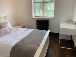 a bedroom with a bed and a desk and a window at 2 bed Serviced Apartment in Henley in Henley on Thames