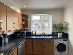 a kitchen with a sink and a washing machine at 2 bed Serviced Apartment in Henley in Henley on Thames +9 photos