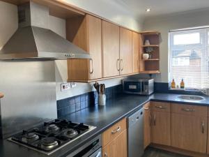 a kitchen with wooden cabinets and a stove top oven at 2 bed Serviced Apartment in Henley in Henley on Thames