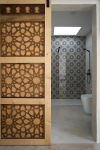un bagno con porta in legno con doccia e WC di B&B Casa Areia a Colares