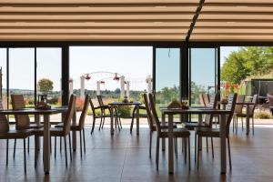 a dining room with tables and chairs and windows at Aquangar in Cehu Silvaniei