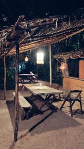 a picnic shelter with a picnic table and benches at Vila Prana in Barra Grande