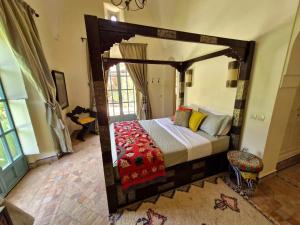 a bedroom with a wooden canopy bed in a room at LA PORTE AU LION - Marrakech in Marrakesh