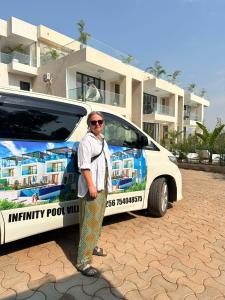 a woman standing in front of a car at Infinity Villas 1 Superking bed Studio Apartment free parking , WiFi , 24 hr security in Entebbe