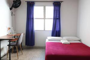メデジンにあるLiving Poblado Manila 301 F Habitación Individualのベッドと机と窓のある寝室