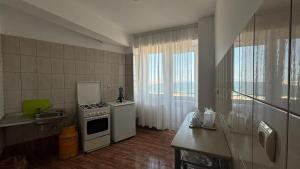 a small kitchen with a stove and a refrigerator at Vila Ilinca in Agigea