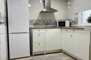 a white kitchen with white cabinets and a microwave at MRS El mirador de la Alcazaba in Antequera +17 photos