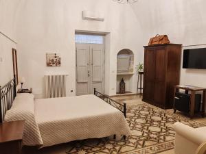 a bedroom with two beds and a flat screen tv at Dimora '900 in Poggiorsini