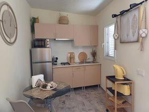 a small kitchen with a table and a refrigerator at Casa Vó Elisa com piscina privada in São Bartolomeu de Messines