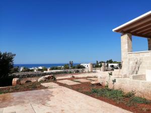 a view of the patio of a house with the ocean in the background at Casina Le Muse in Marina di Pescoluse