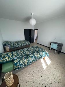 a room with two beds and a desk in it at Maison 2 chambres 3 lits 4 couchages et extérieur in Villefranche-de-Lauragais