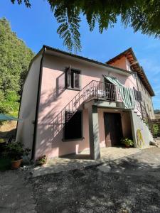 una casa rosa con una escalera en el lateral de ella en All'Agacino, en Lucca