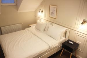 een bed met witte lakens en kussens in een kamer bij Lev Or Aparthotel in Boekarest +57 foto's