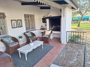 a patio with chairs and a table and a fireplace at Rooiheuwel Cottage in Wellington