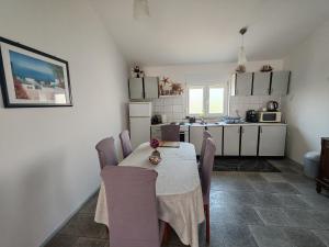a kitchen and dining room with a table and chairs at Apartman Olic in Ražanac