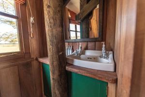 een badkamer met een wastafel en een spiegel bij The Watch Tower 360' Bed View Shower Understars in Naivasha