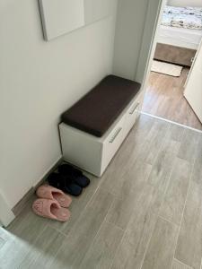 a room with two pairs of flip flops and a bench at Apartman Nana in Banja Koviljača +26 photos